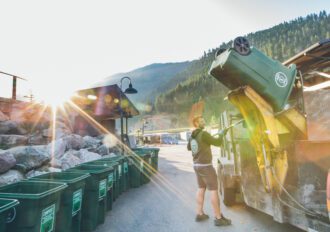 Missoula Compost company employee emptying bins into a truck.