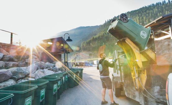 Missoula Compost company employee emptying bins into a truck.