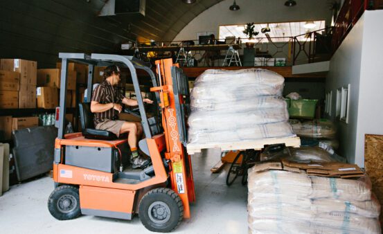 Fork lift operator moving bags of coffee beans at a local coffee roasters.