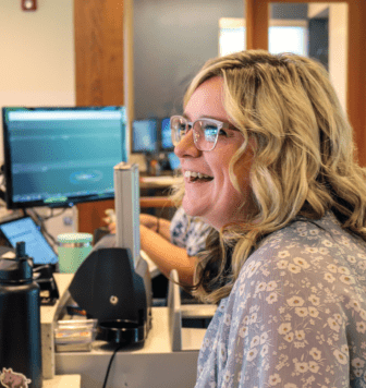 Clearwater staff member smiling at a customer at the Brooks St. Branch.