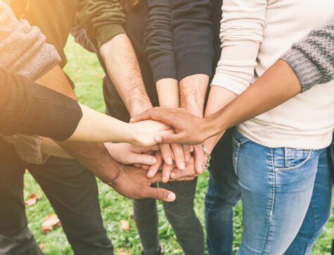 Multiracial Group of Friends with Hands in Stack demonstrating teamwork.