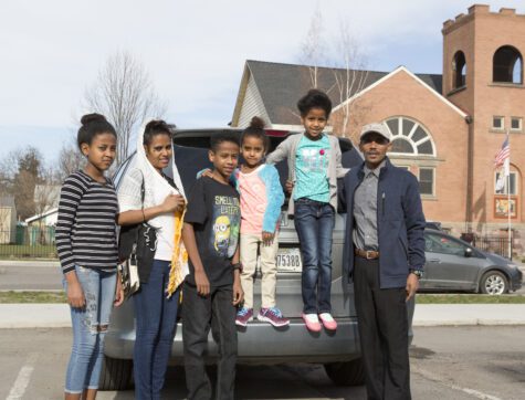 Clearwater Credit Union member, Desbele Tekle and his family in front of their car.