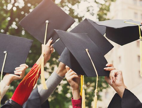 Graduates holding their caps in the air