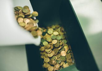 Close up of coins going in to a coin counter machine.