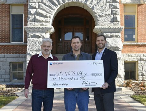 Three men holding a large fake check for Clearwater Credit Union Donation to Spark Giving for Veteran Student Scholarships