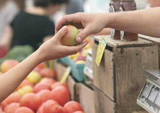 Adult handing an apple to a child