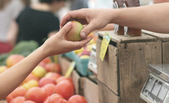 Adult handing an apple to a child