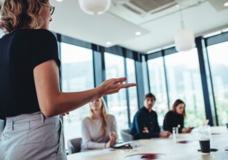 Businesswoman making a presentation to her colleagues in office. Office colleagues sitting at the conference room while listening to a presentation.