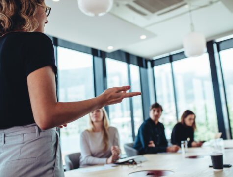 Businesswoman making a presentation to her colleagues in office. Office colleagues sitting at the conference room while listening to a presentation.