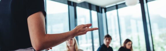 Businesswoman making a presentation to her colleagues in office. Office colleagues sitting at the conference room while listening to a presentation.