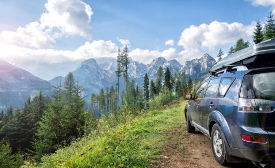 car traveling on a mountain road in summer.