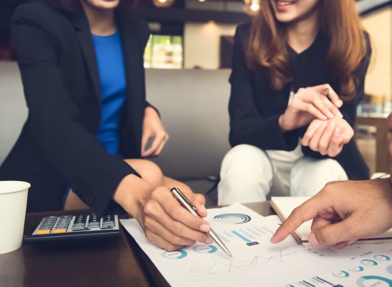 Financial adviser working with clients analyzing data at the table in cafe