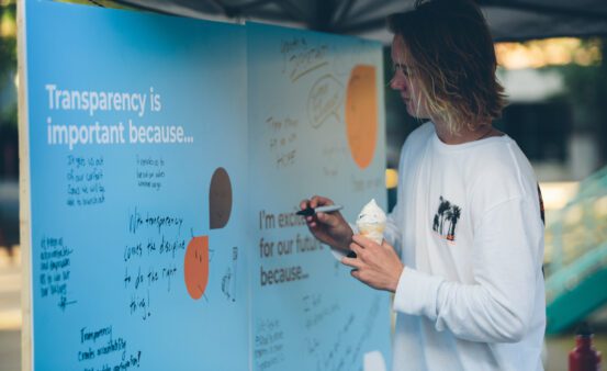 A young man writes on a response board the 2019 Annual Member Meeting.