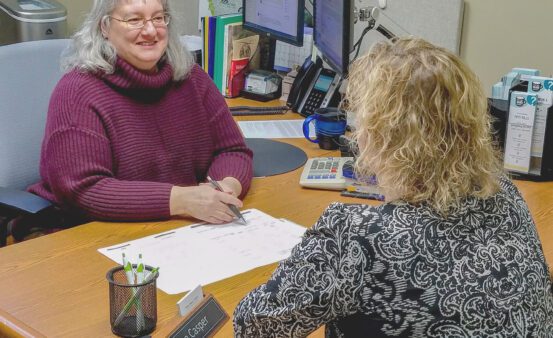 Clearwater staff person talks to a member about financial education at a Missoula member event in Missoula, MT.