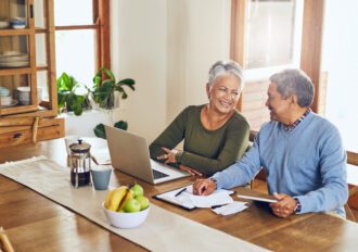 Finance, laptop and happy senior couple with bills, paperwork and documents for life insurance. Retirement, pension and elderly man and woman on computer for mortgage payment, investment and budget.