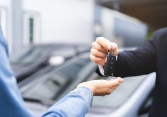 Woman receiving car keys from a mans hand.