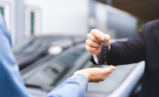 Woman receiving car keys from a mans hand.