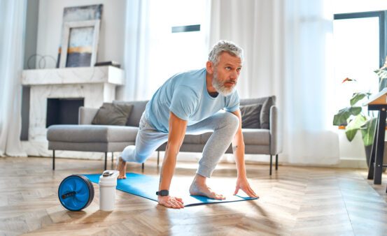 Mature man doing exercises at home.