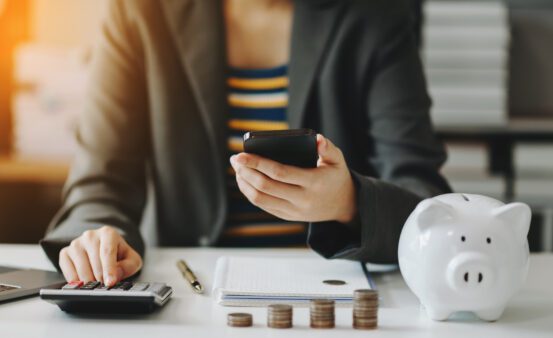 Business accountant working on desk using mobile phone and calculator to calculate budget concept finance and accounting