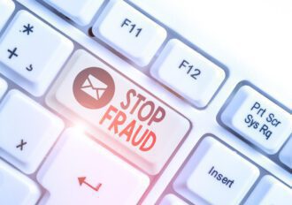 White pc keyboard with empty note paper above white background and one key that says "Stop Fraud."