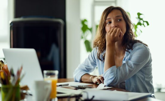 Young worried woman thinking of something while calculating her home budget.