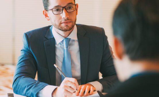 businessman in suit speaking with another person in meeting